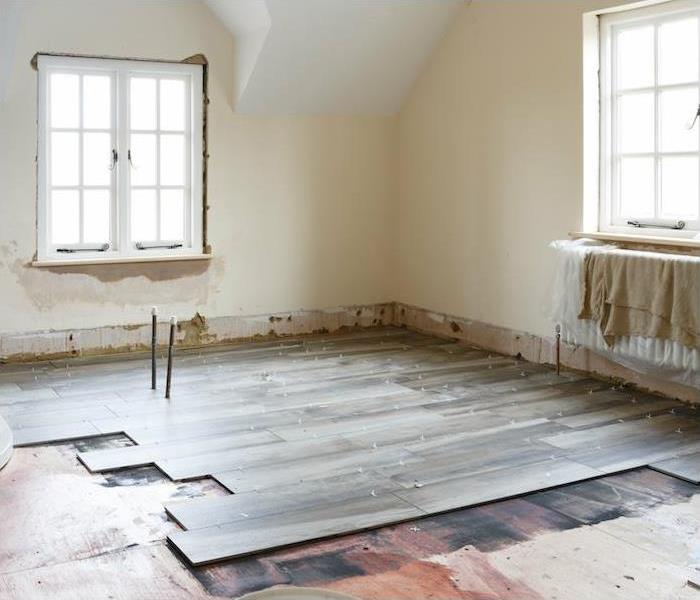 a small interior room with light brown wood floor being installed